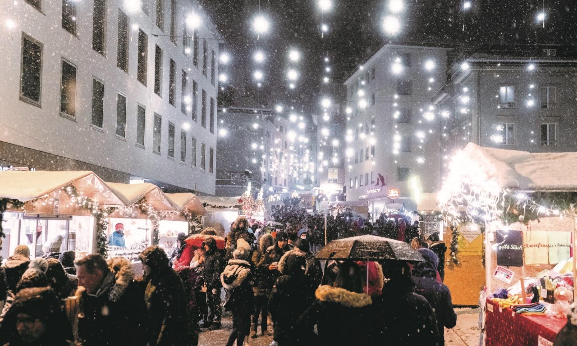 Einsiedler Weihnachtsmarkt auf Hauptstrasse Richtung Kloster mit festlicher Strassenbeleuchtung