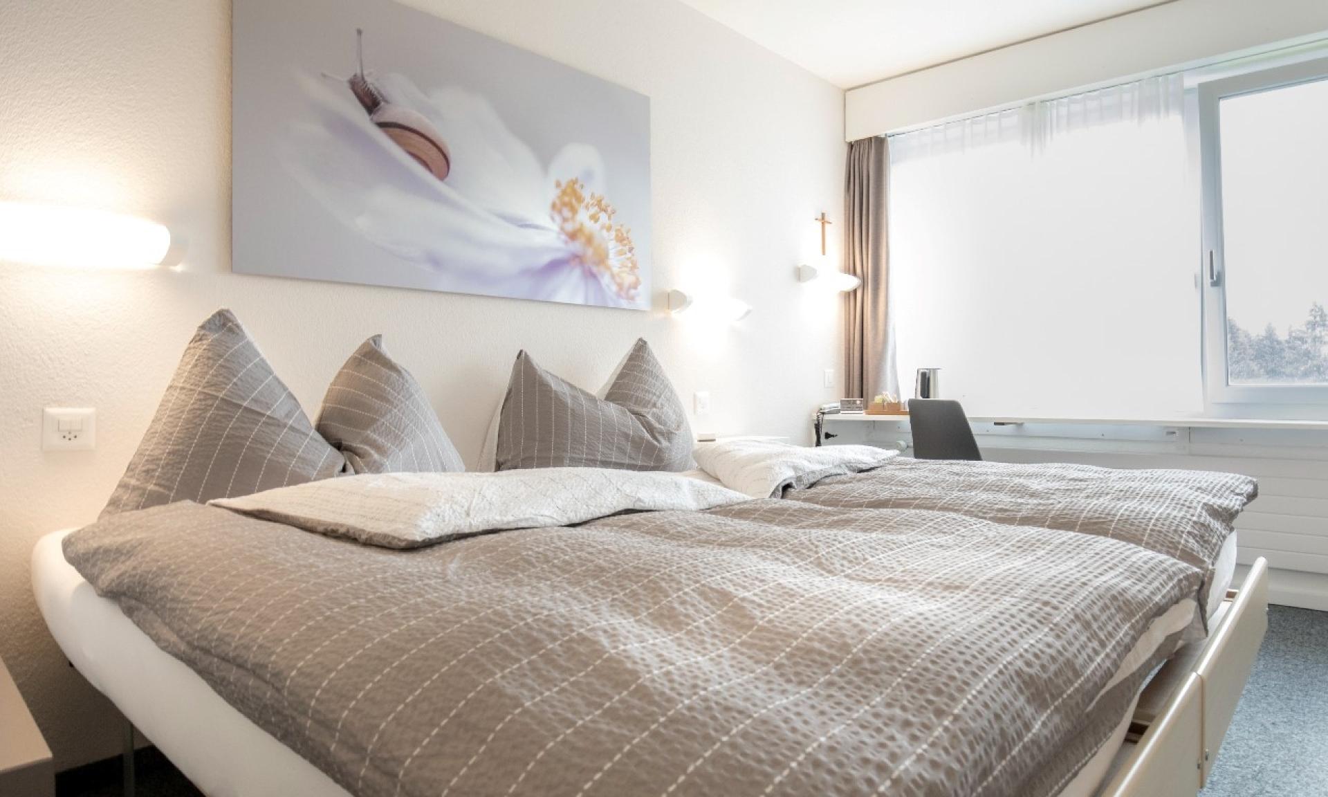 Doppelbett mit gemütlichen Decken und Kissen in einem schönen Zimmer